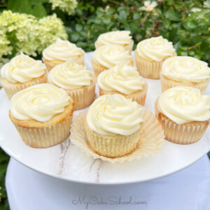 Banana Cupcakes on a pedestal, swirled with cream cheese frosting.