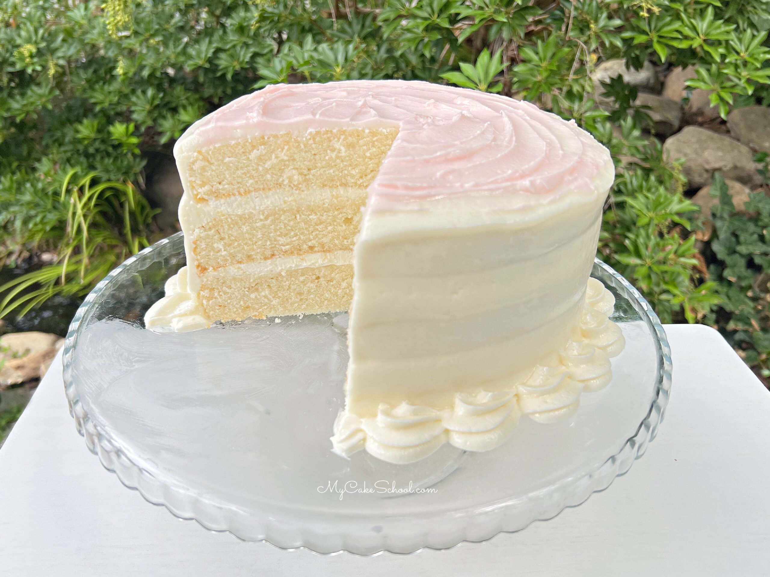 Sliced Homemade White Cake on a cake pedestal.