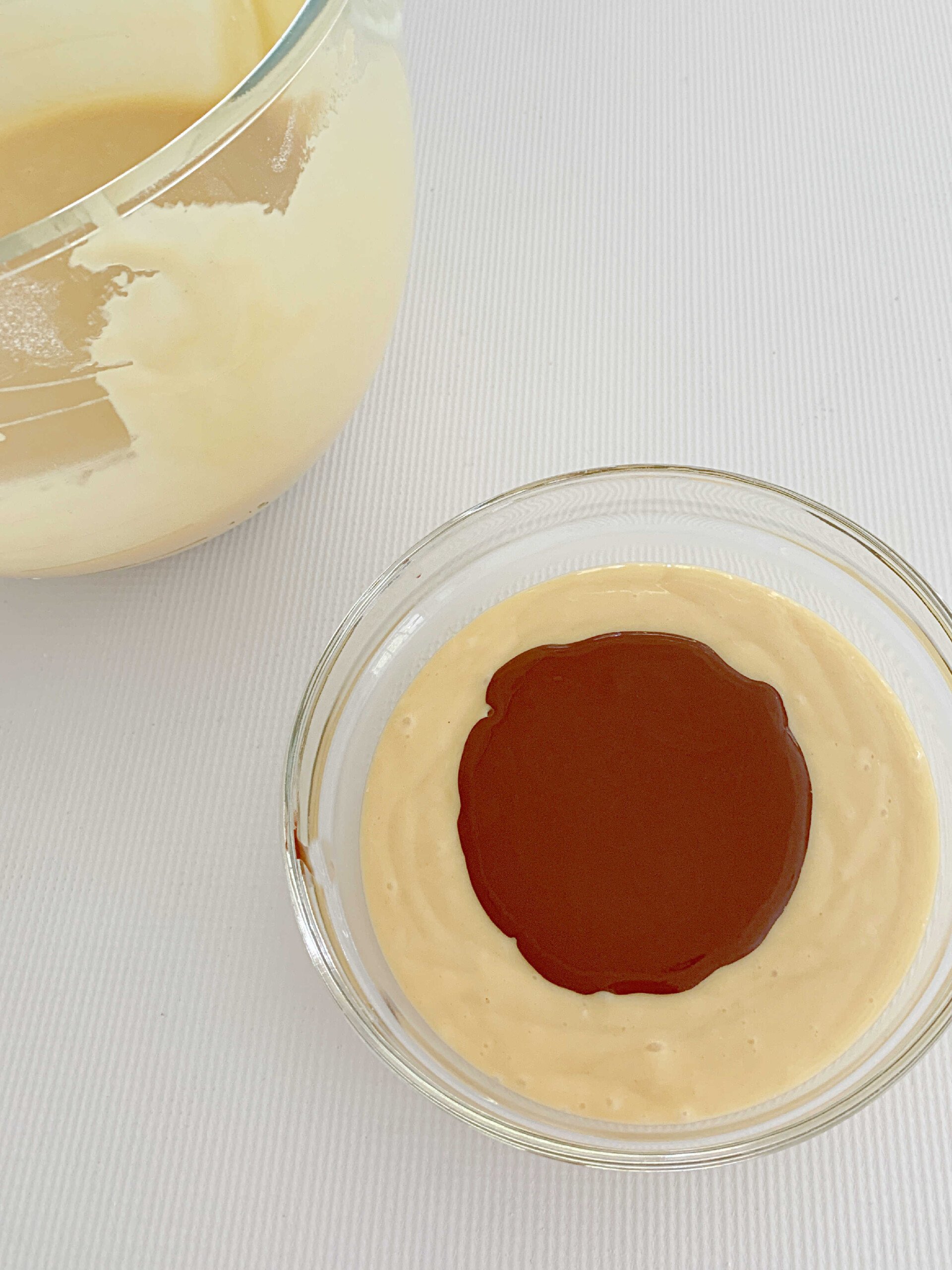 Bowl of two cups of yellow cake batter, with cocoa mixture added to it.