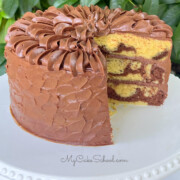 Marble Cake from Cake Mix, sliced, on white cake pedestal outside.