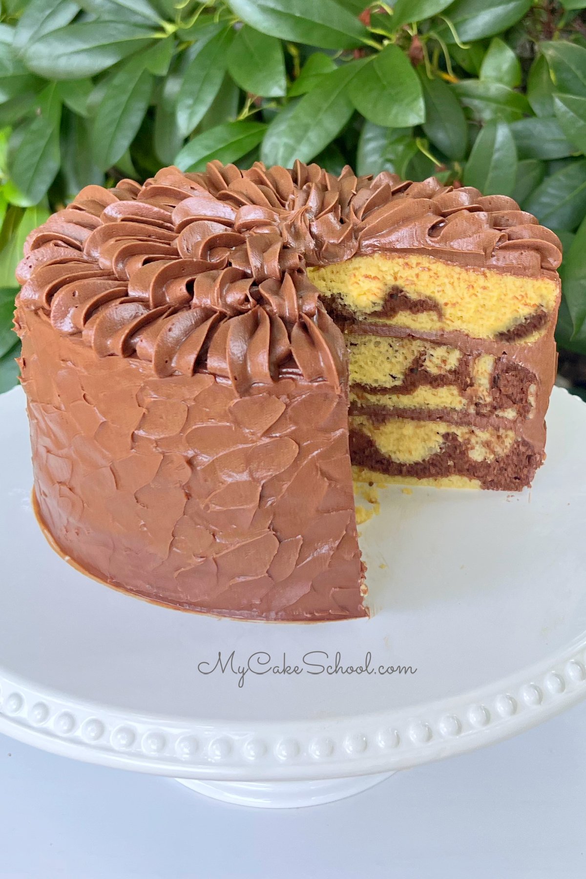 Marble Cake from Cake Mix, sliced, on white cake pedestal outside. 