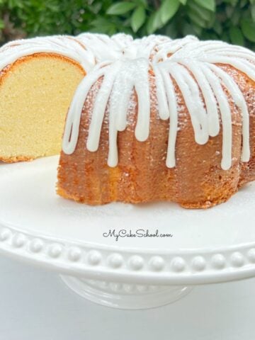 Sliced Cream Cheese Pound Cake on white pedestal.