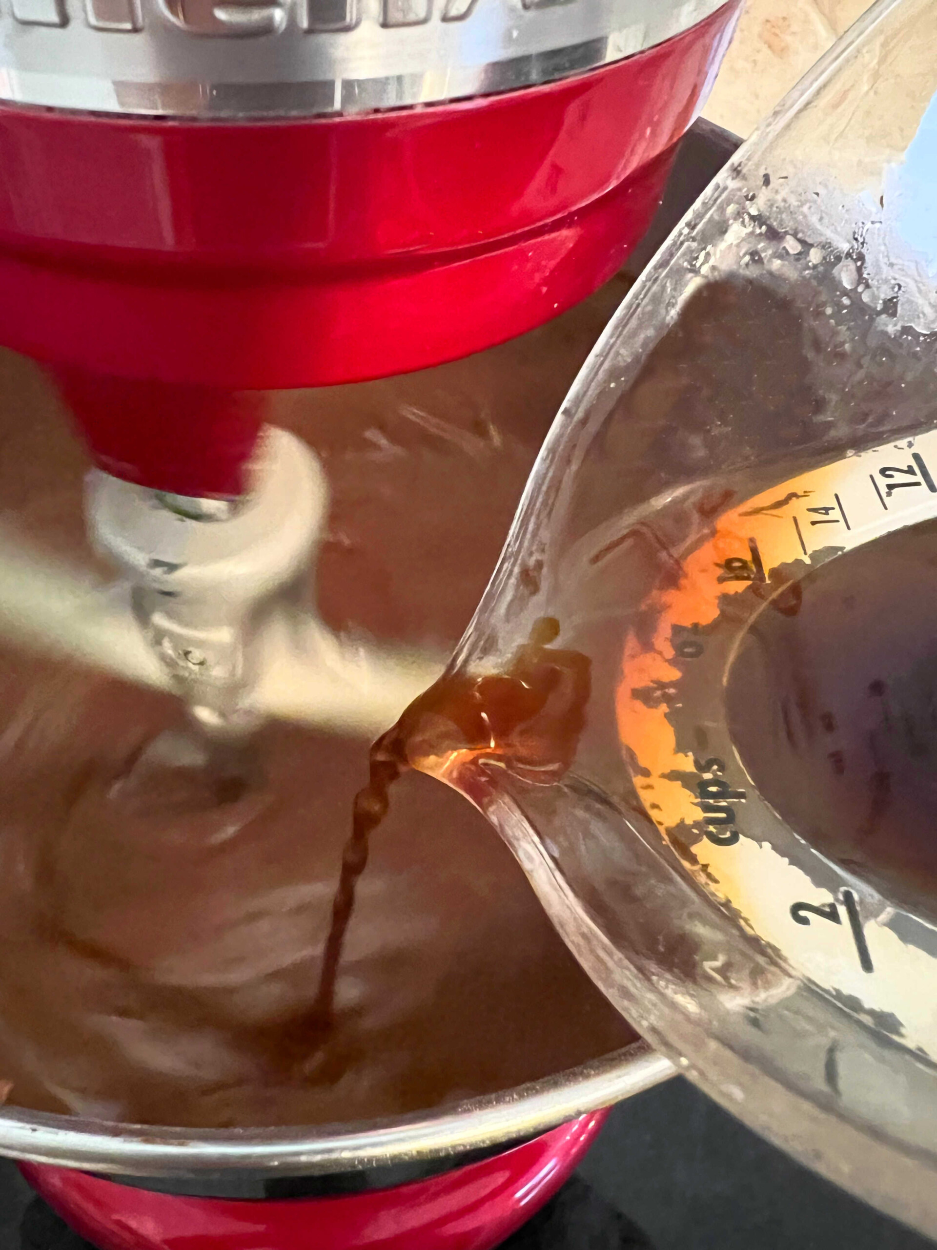 Pouring coffee into the chocolate cake batter while mixing.