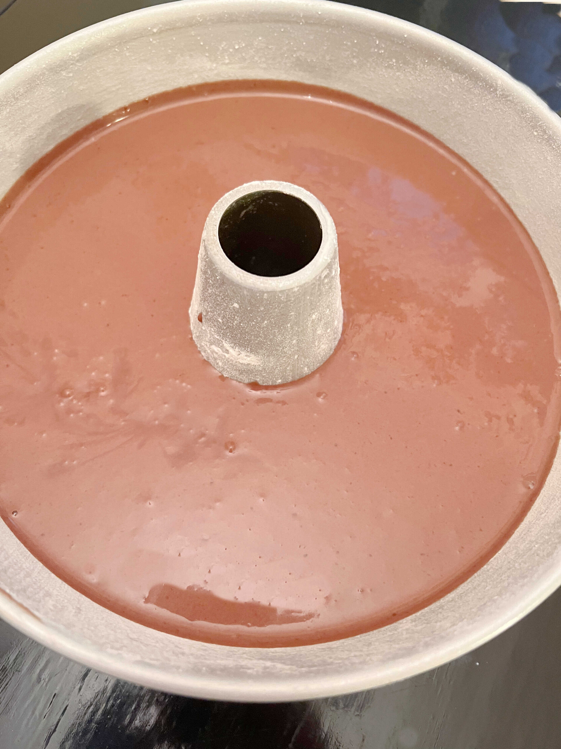 Tube pan filled with chocolate bundt cake batter.