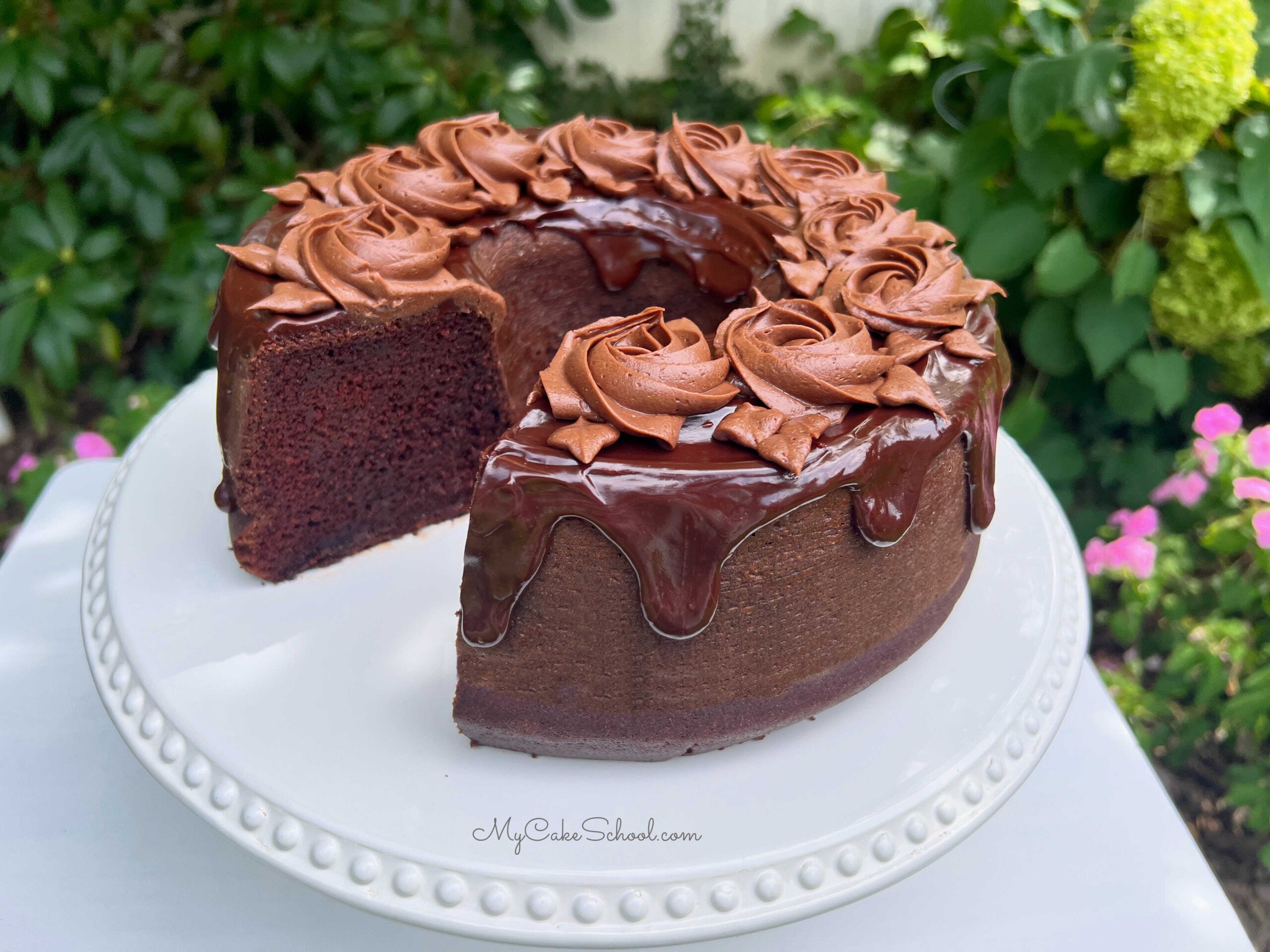 Sliced chocolate bundt cake, topped with chocolate glaze and chocolate buttercream rosettes.