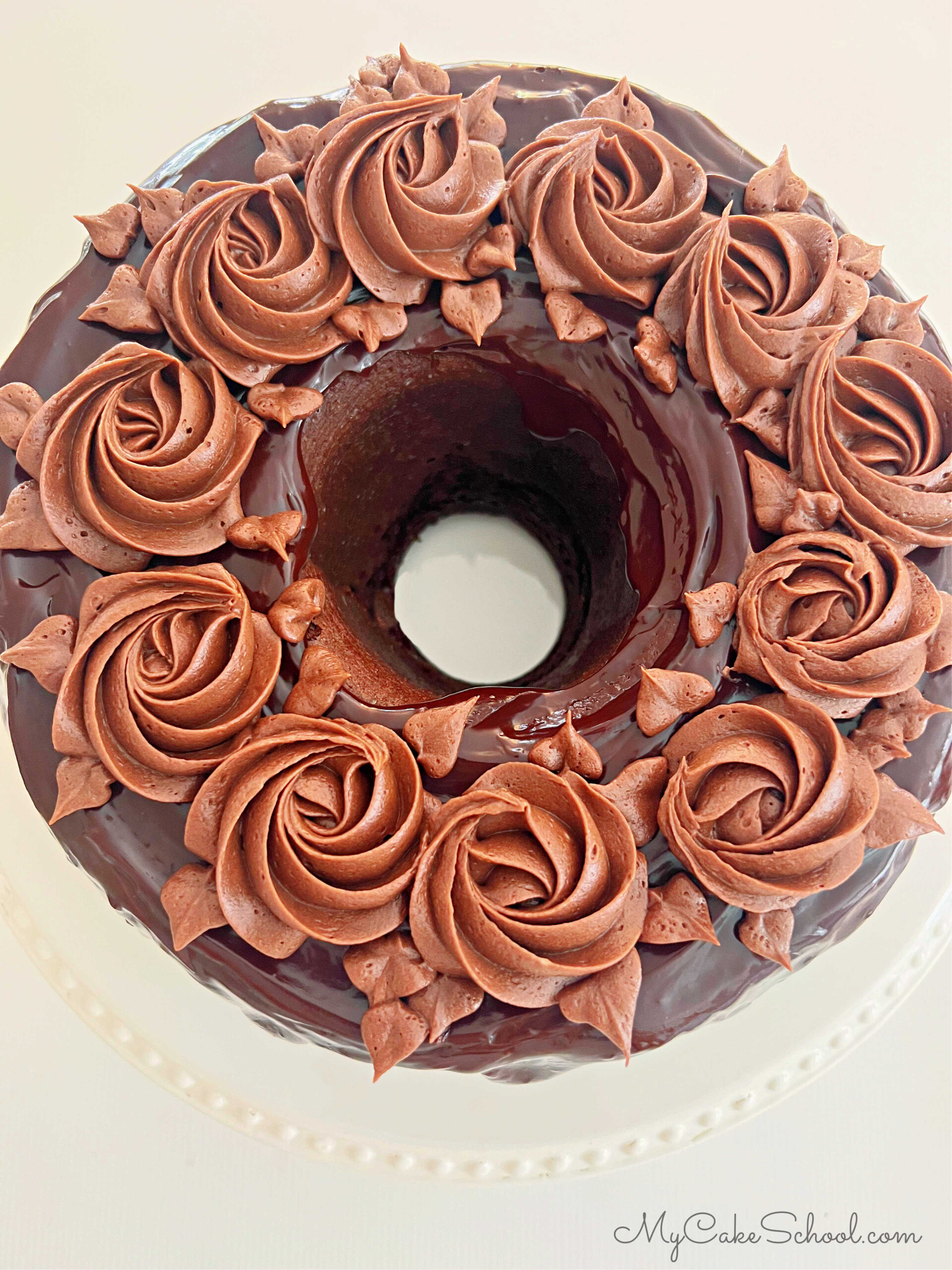 Top view of scratch chocolate bundt cake, topped with rich chocolate glaze and chocolate buttercream rosettes. 