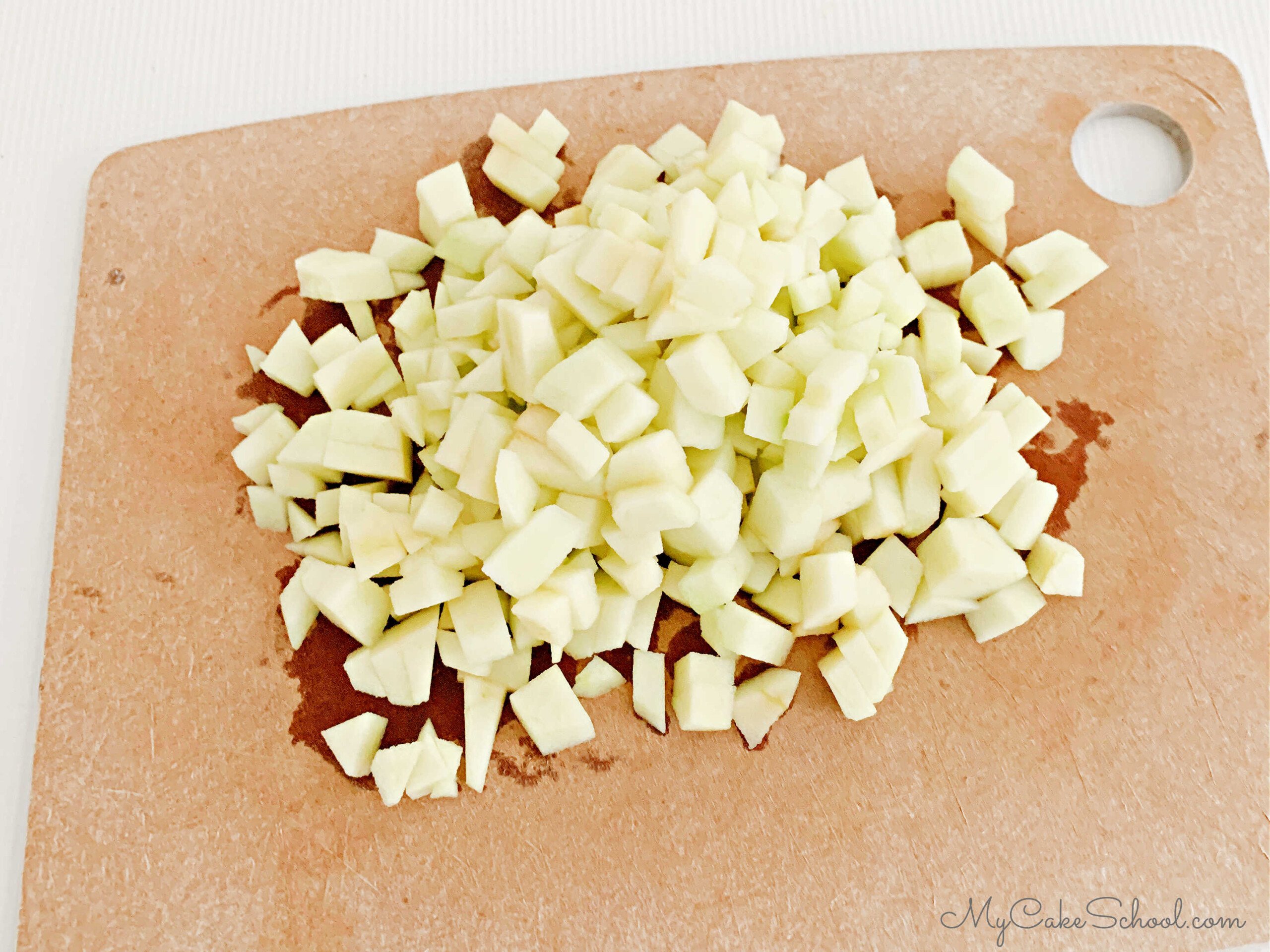 Diced Granny Smith Apples on a cutting board.