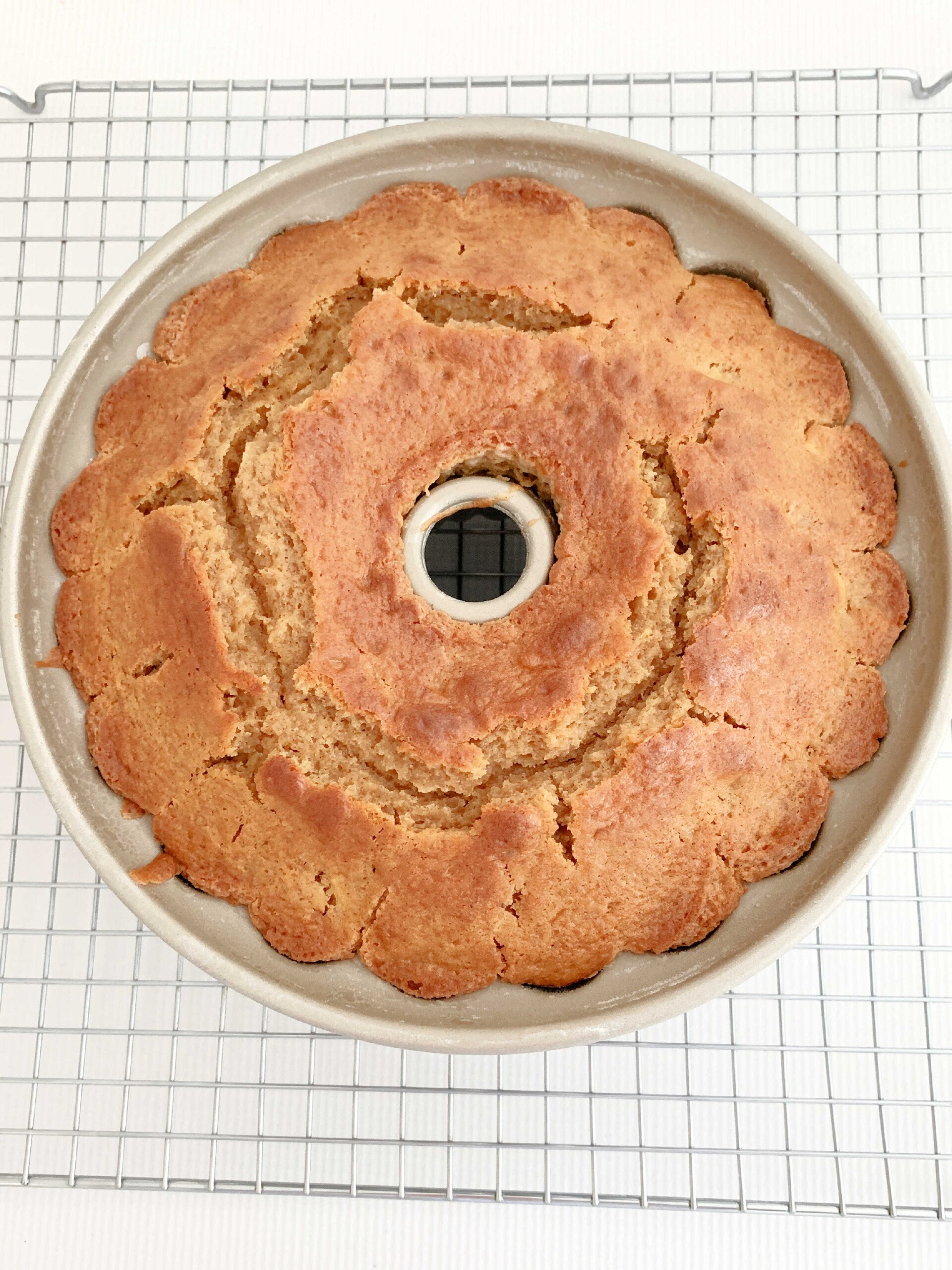 Baked Apple Bundt Cake, freshly baked, in bundt pan cooling on wire rack.