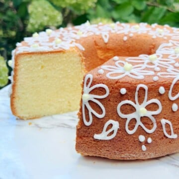 Sliced Lemon Cream Cheese pound Cake on a white pedestal.