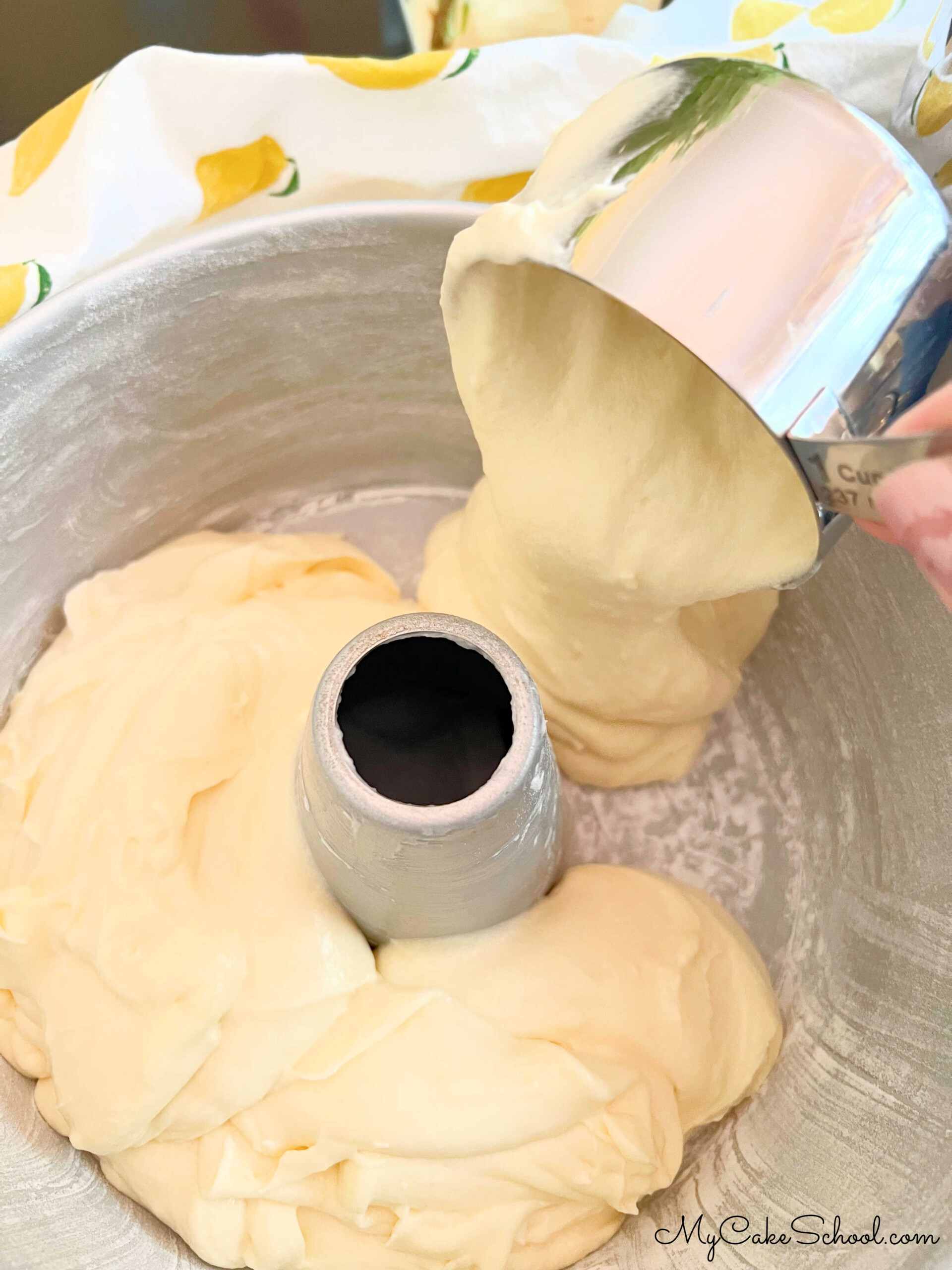 Adding the Lemon Cream Cheese Pound Cake Batter to the prepared tube pan.