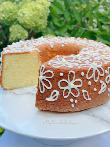 Lemon Cream Cheese Pound Cake, sliced, on a white pedestal.