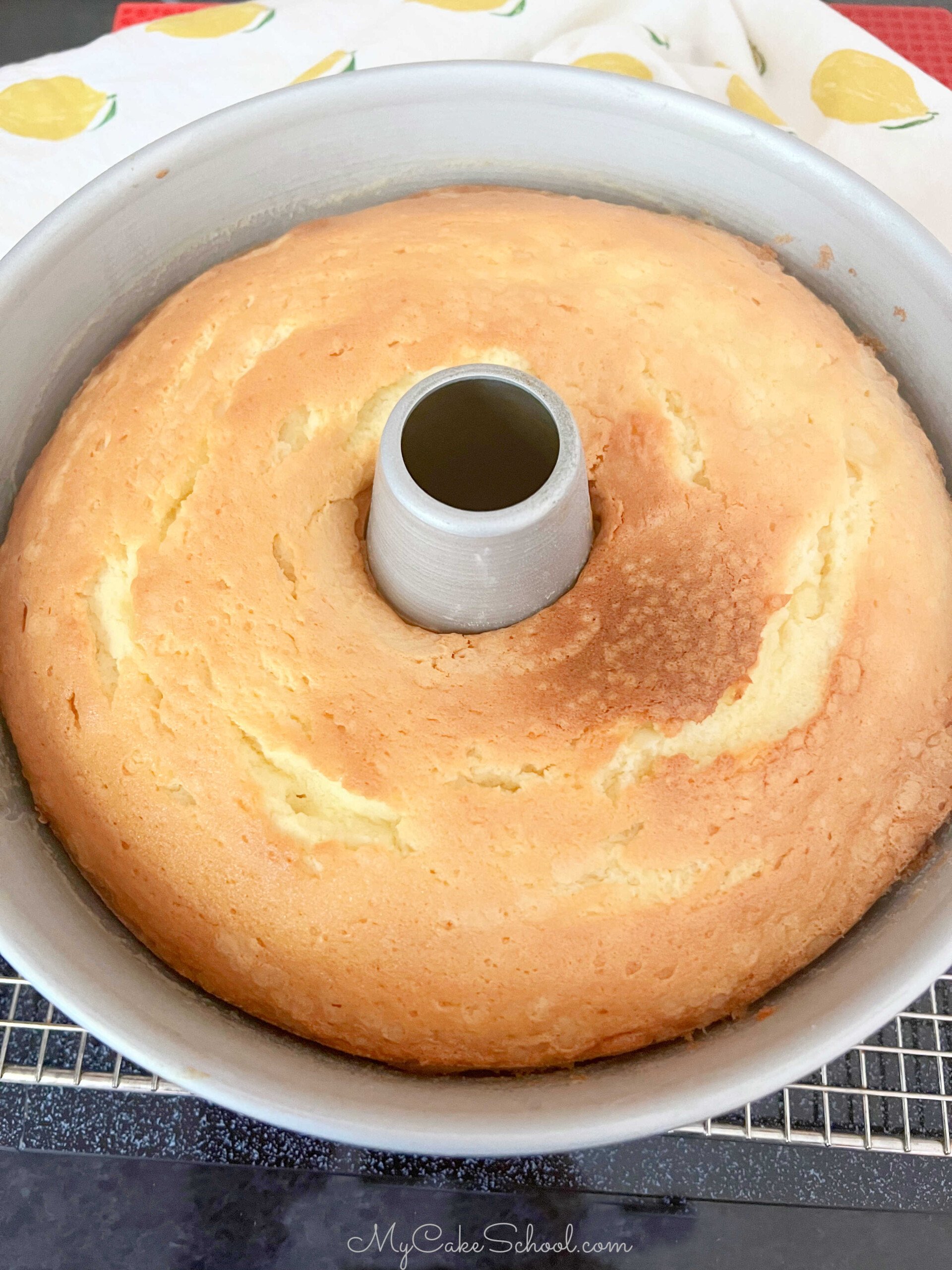Freshly Baked Lemon Cream Cheese Pound Cake, in tube pan on a cooling rack.