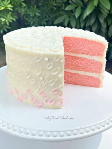 Pink Velvet Cake, sliced on a white pedestal.