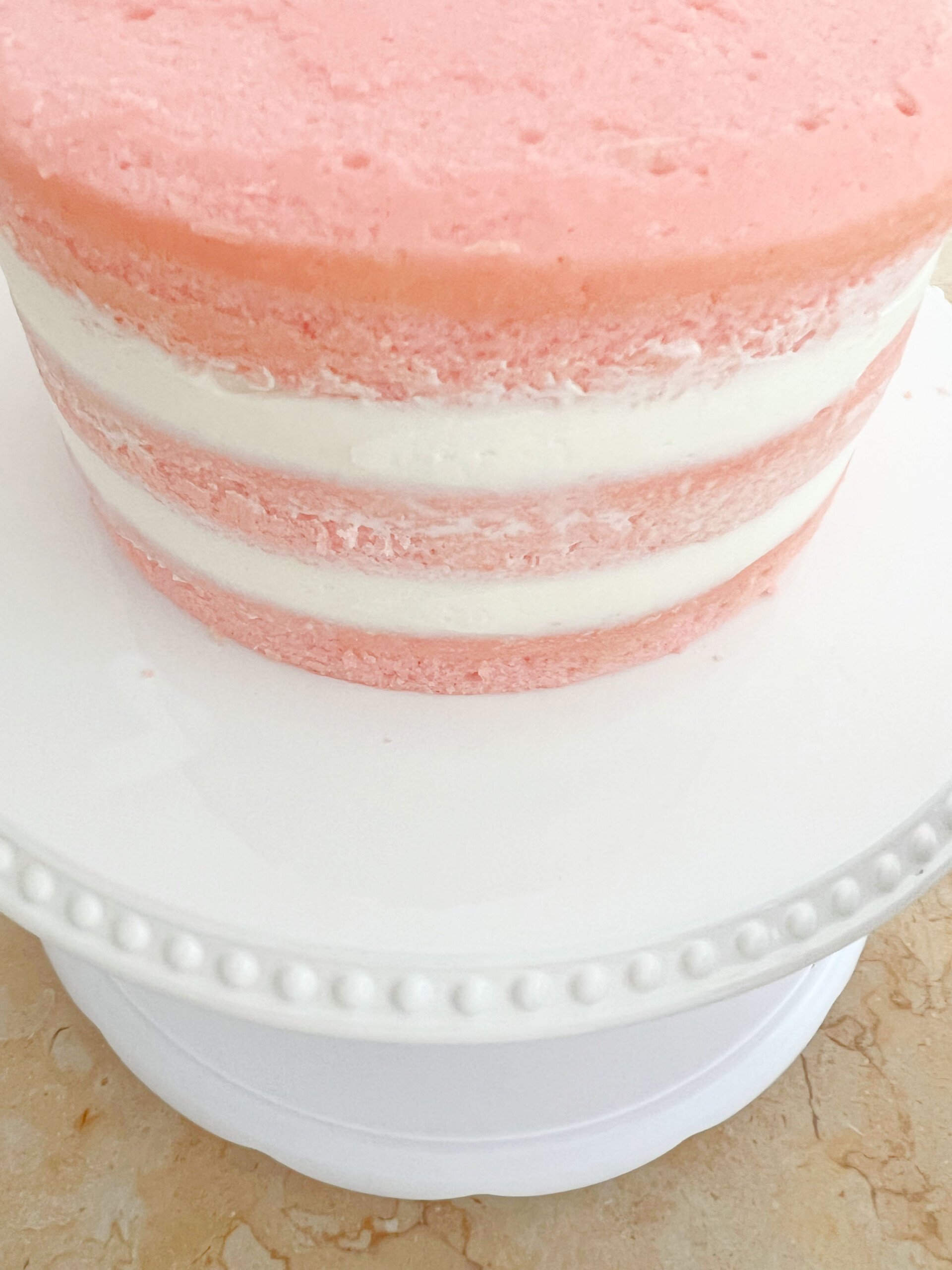 Pink Velvet Cake on white cake pedestal.
