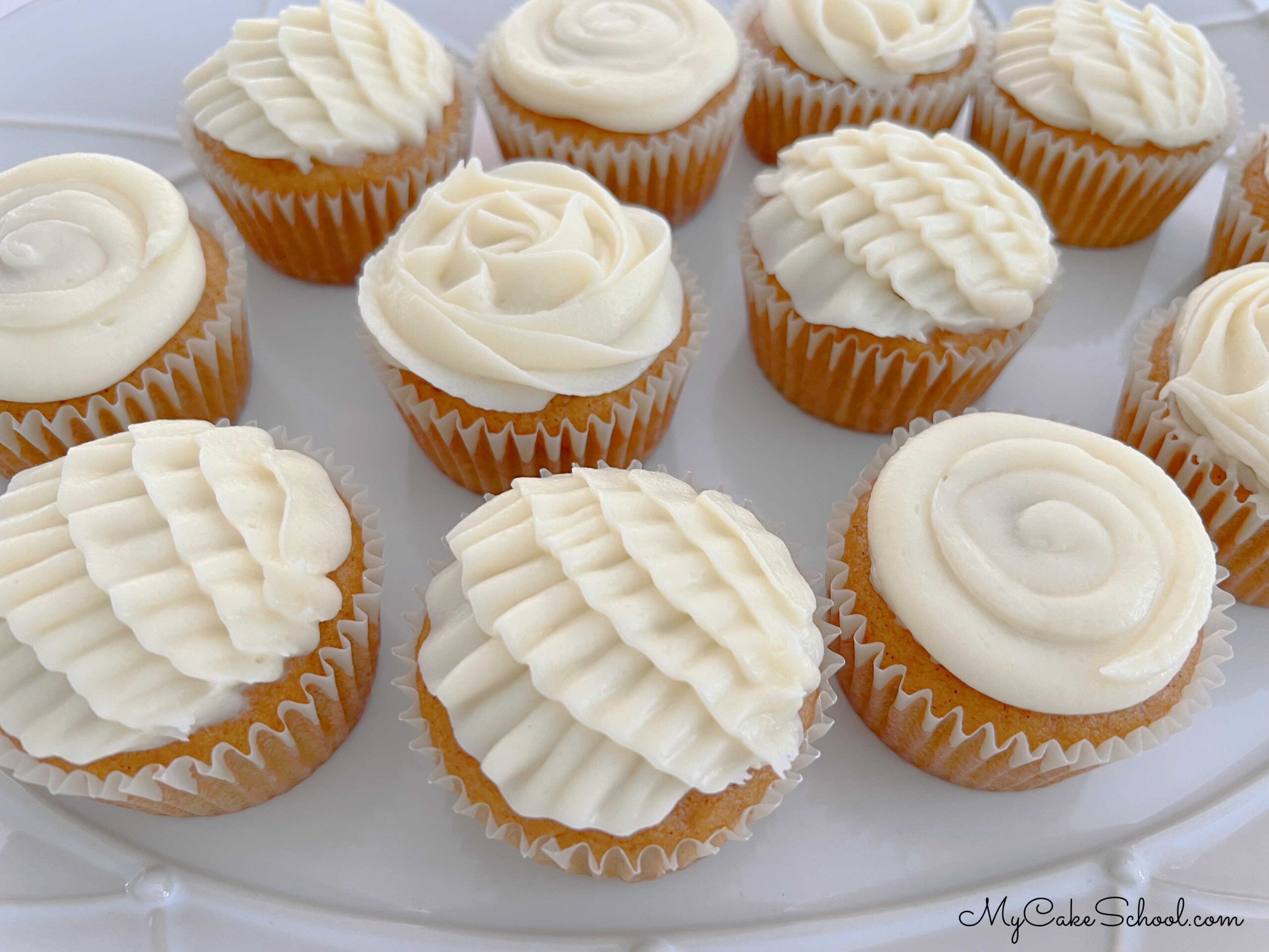 Platter of Pumpkin Cupcakes with Decorative Cream Cheese Piping.