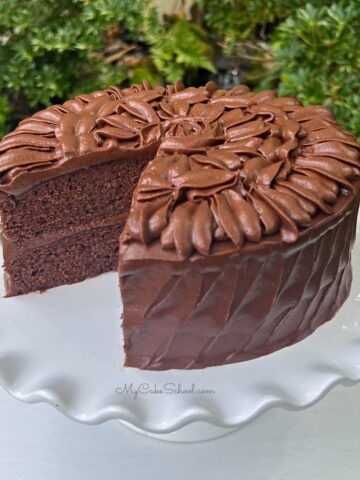 Sliced Brownie Cake on a white cake pedestal.