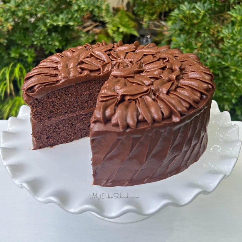 Sliced Brownie Cake on a white cake pedestal.