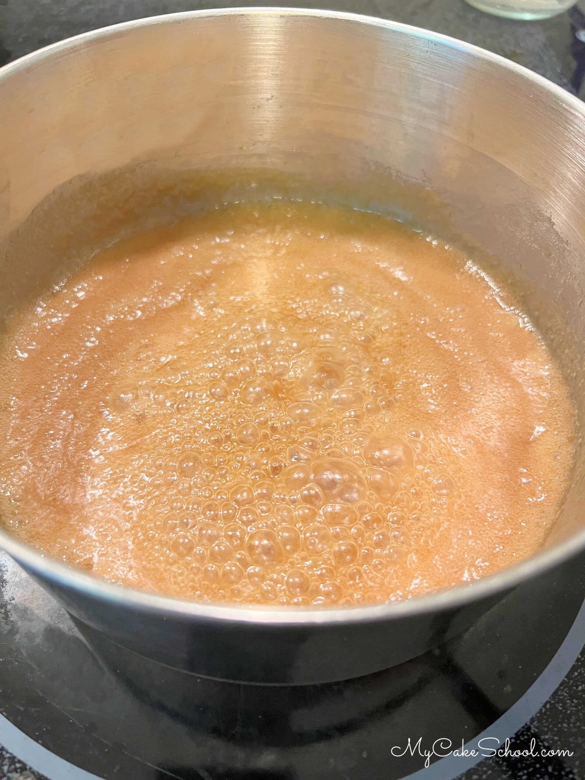 Saucepan of simmering caramel sauce.