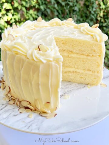 Lemon Almond Cake, sliced, on a pedestal.