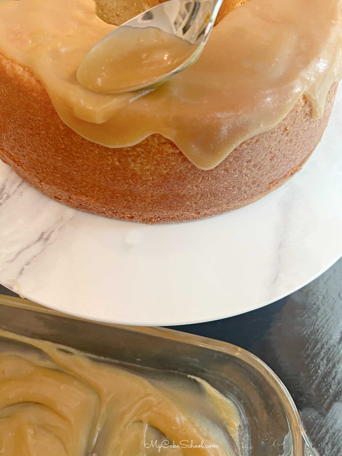 Spooning caramel glaze over the maple pound cake.