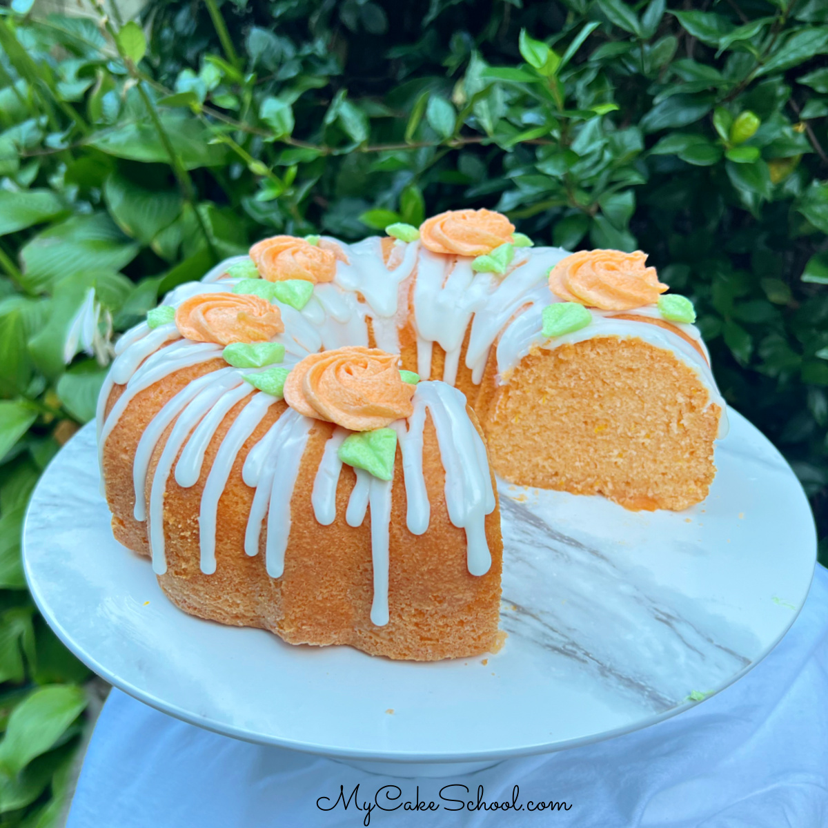 Sliced Orange Bundt Cake on cake pedestal.