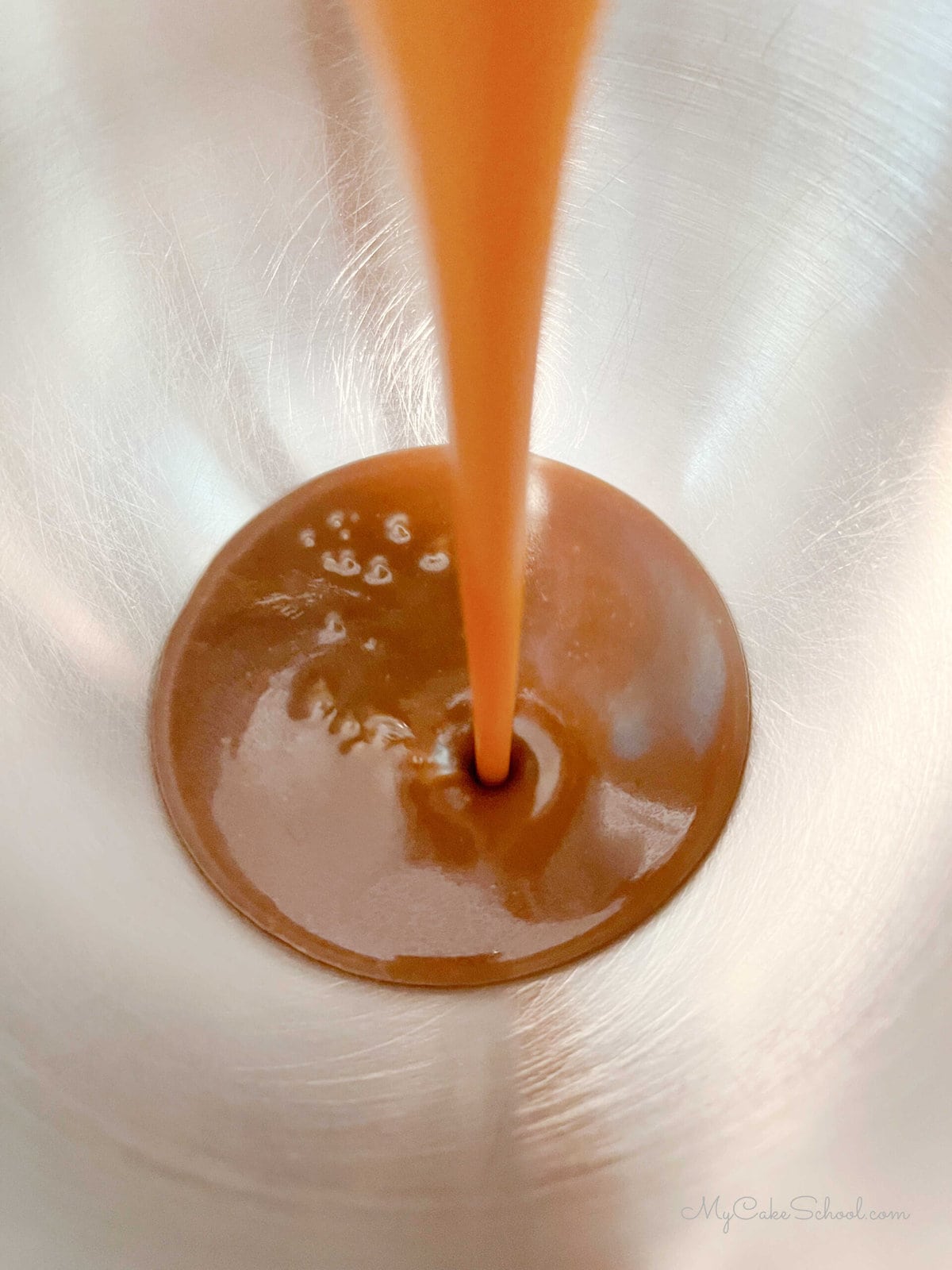 Pouring Caramel Sauce into mixing bowl to make frosting.