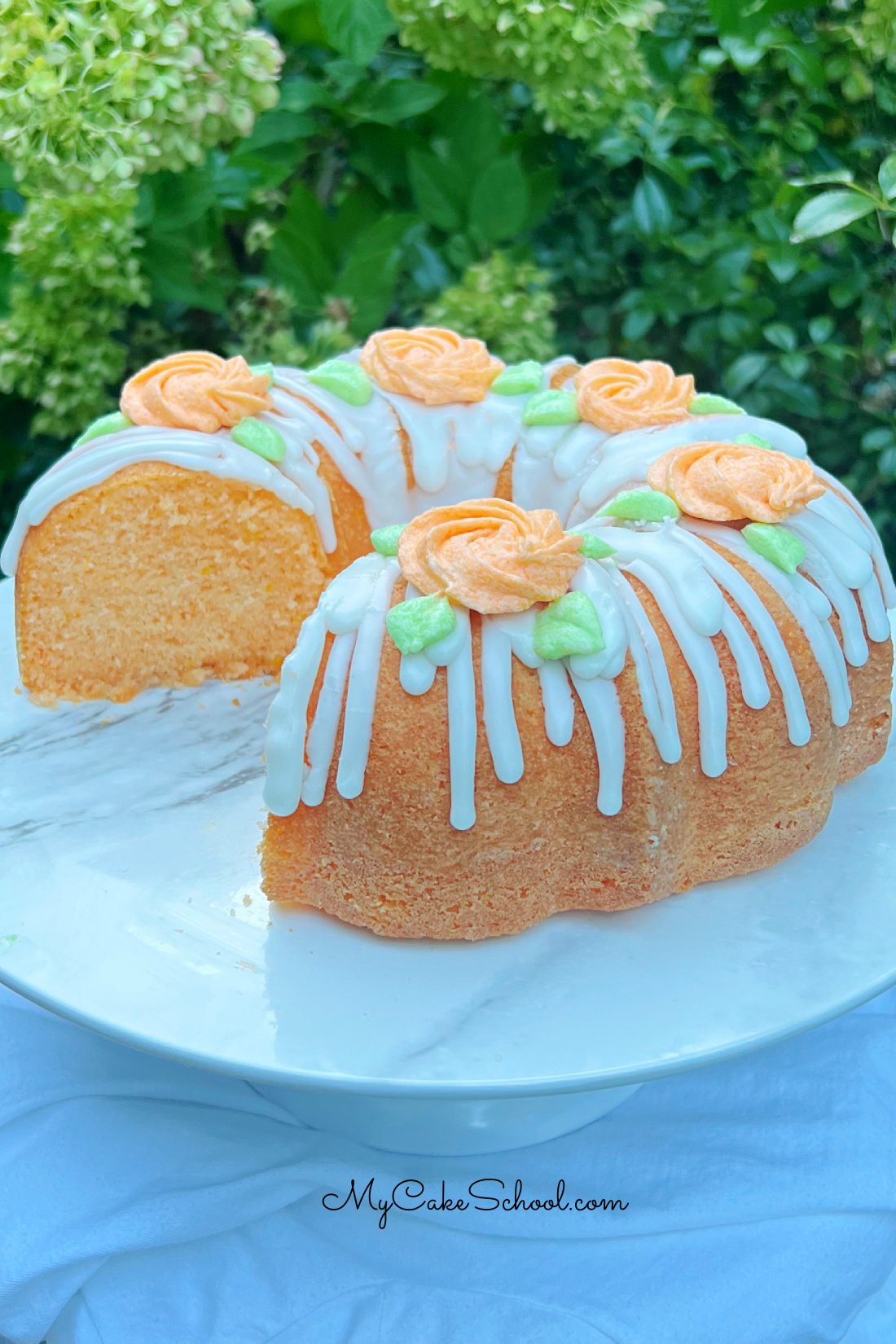 Orange Bundt Cake, sliced, on a cake pedestal.