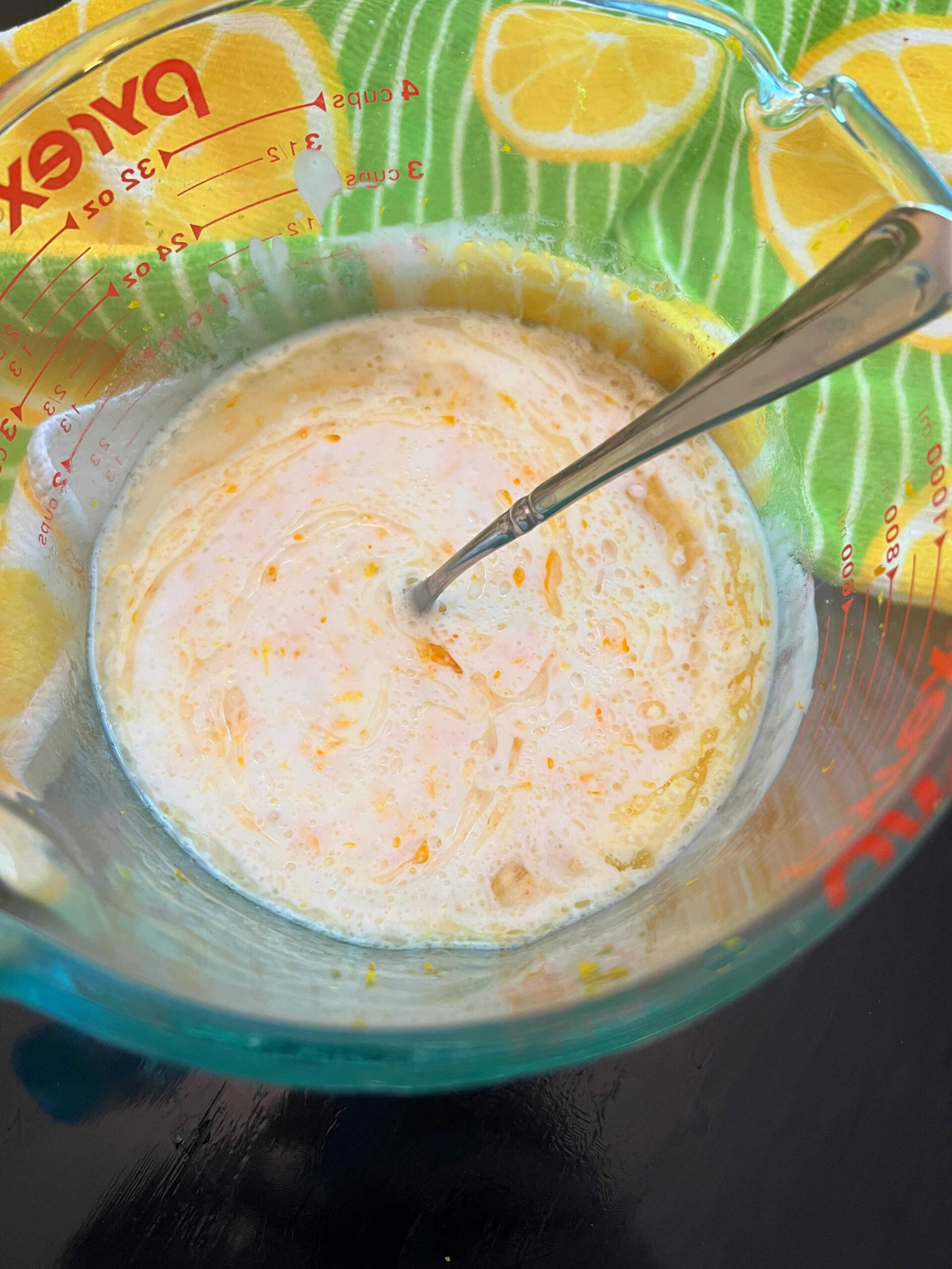 Measuring cup of wet ingredients for orange bundt cake.