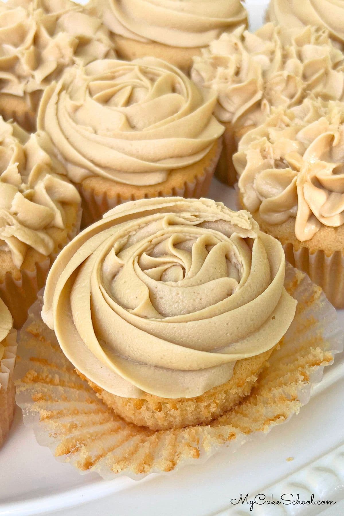 Closeup photo of cupcakes frosted with caramel frosting.