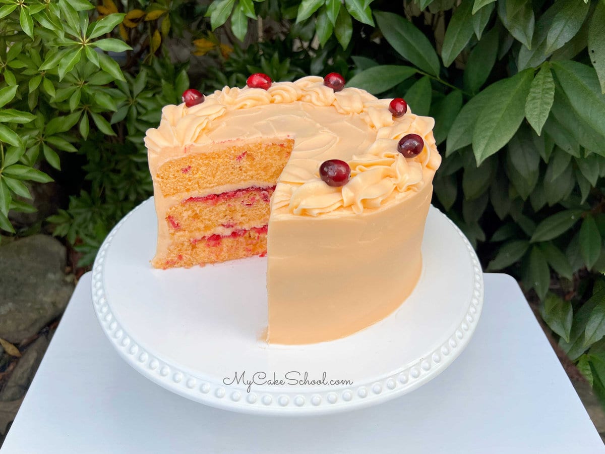 Sliced Cranberry Orange Cake on a white pedestal.