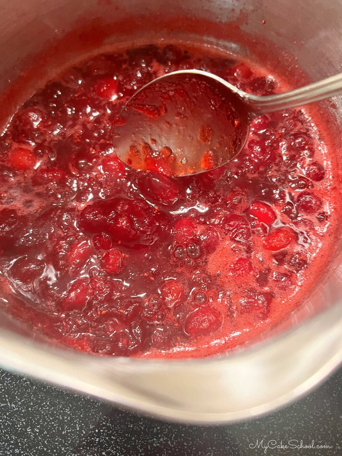 Heating cranberry filling in a saucepan.