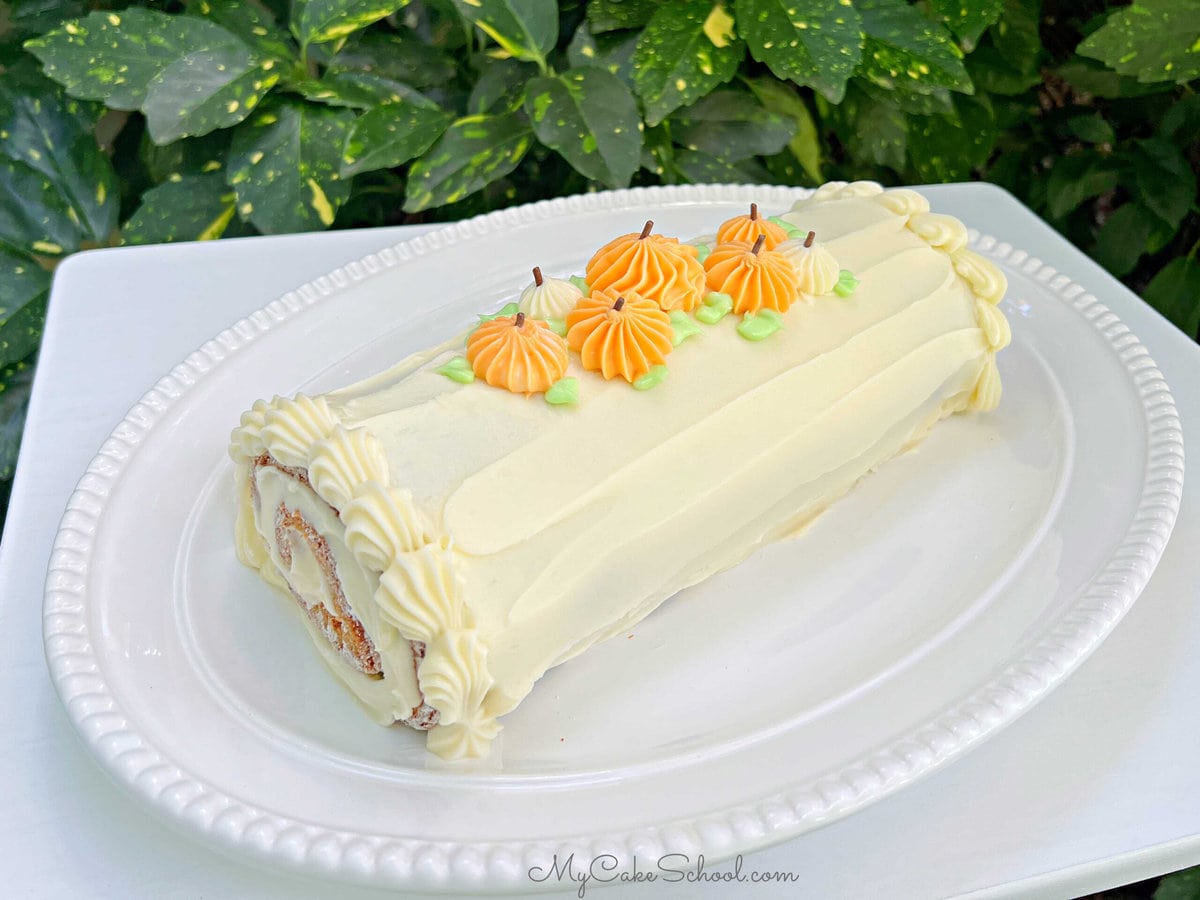 Pumpkin Roll Cake decorated with piped pumpkins.