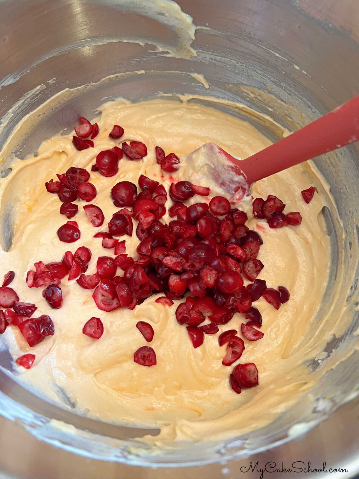 Adding cranberries to Orange Cake Batter.