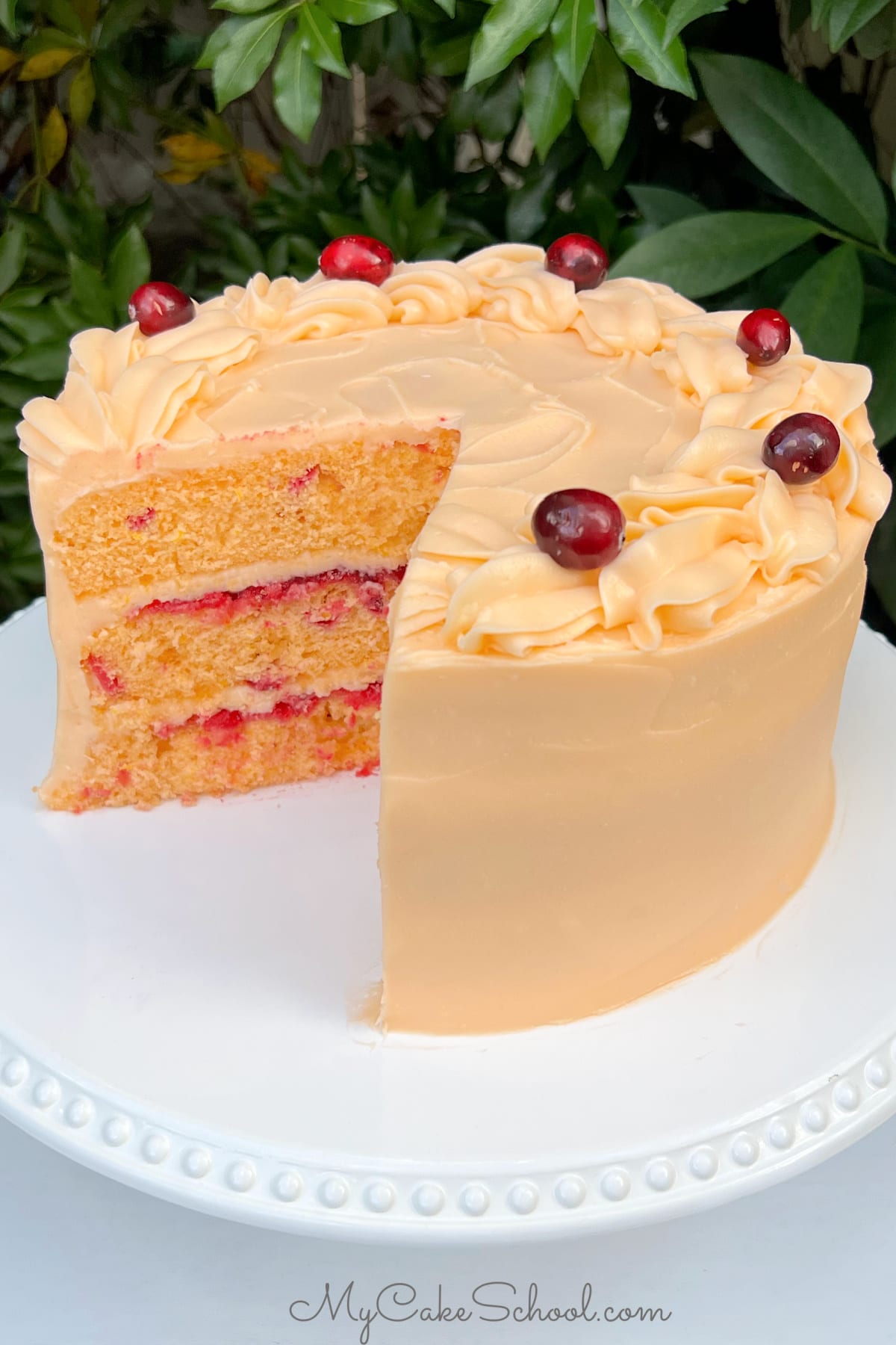 Sliced Cranberry Orange Cake in a white cake pedestal.