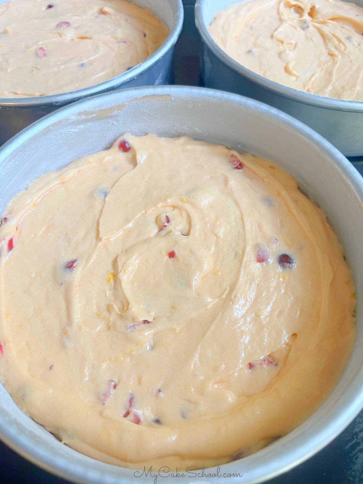 Three pans of Orange Cranberry Cake batter.