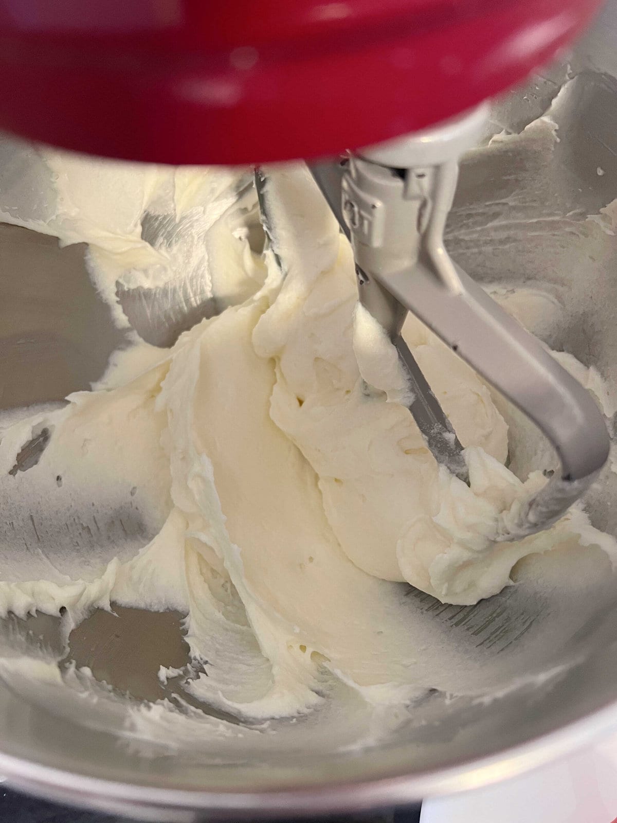 Mixture of butter, cream cheese, and sugar in mixing bowl.