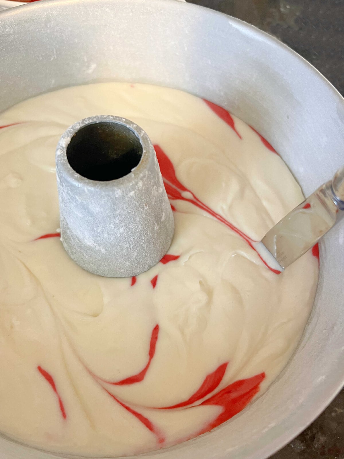 Marbling the cake batter in the pan with a knife.