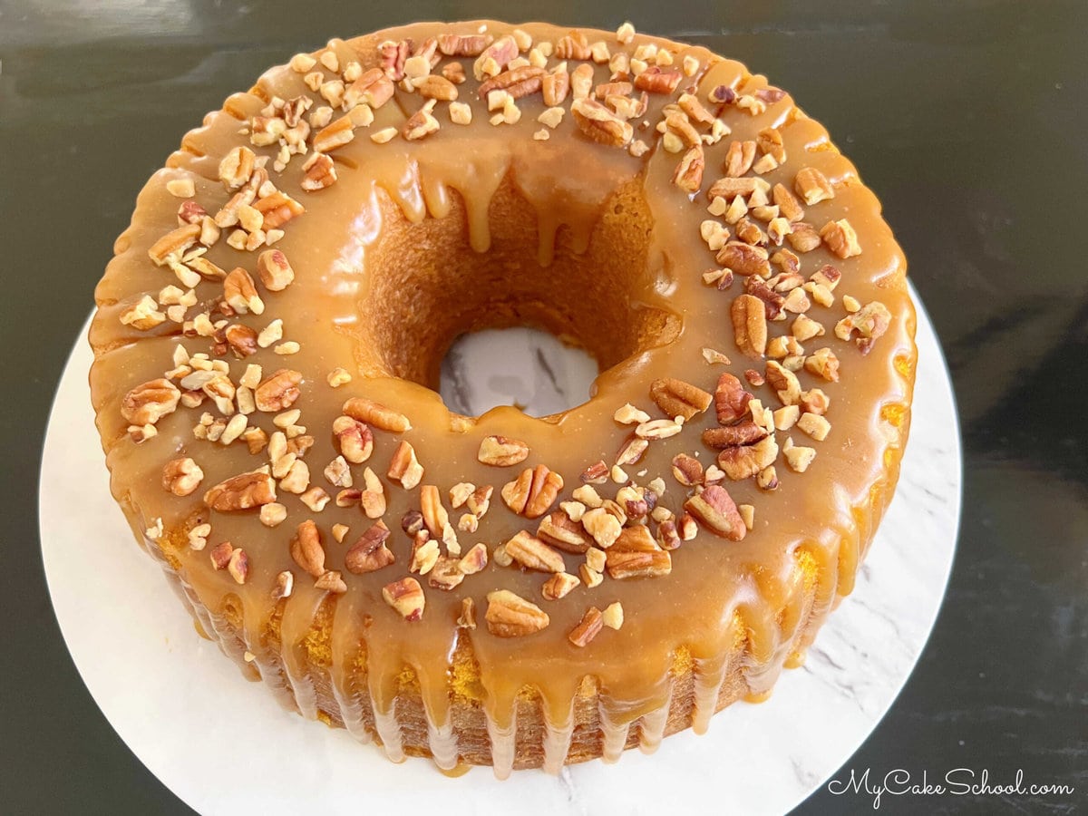 Pumpkin Bundt Cake with caramel glaze, topped with pecans and toffee bits.
