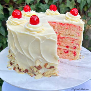 Cherry Almond Cake, sliced, on a cake pedestal.