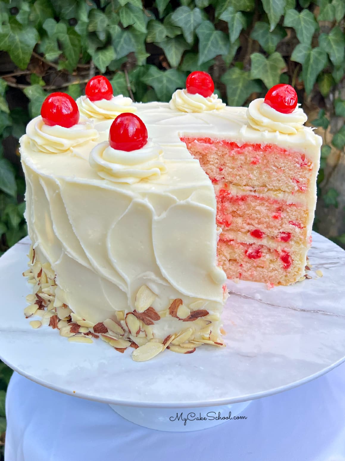 Cherry Almond Cake, sliced, on a cake pedestal.