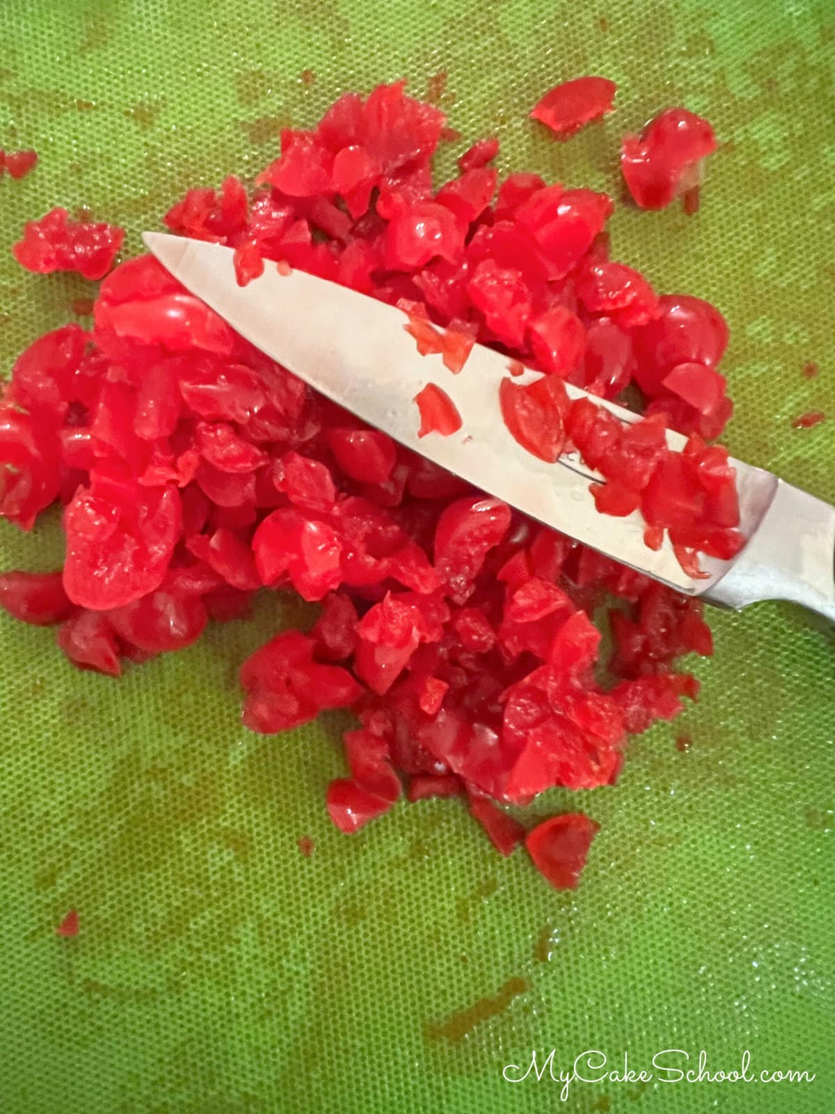 Chopped cherries on cutting board.