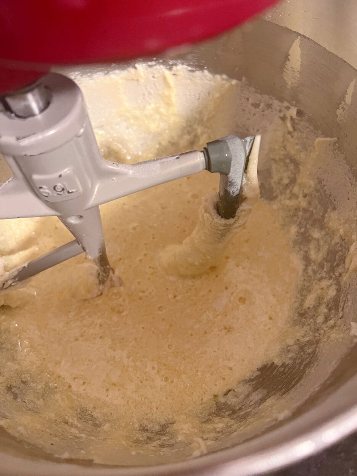 mixing eggs into butter and sugar mixture in bowl.