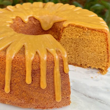 Sliced gingerbread bundt cake on cake pedestal with caramel glaze.