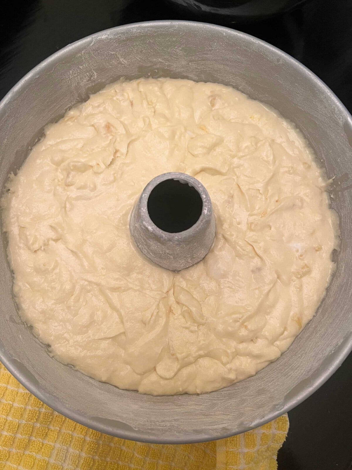 Tube pan filled with pineapple pound cake batter.