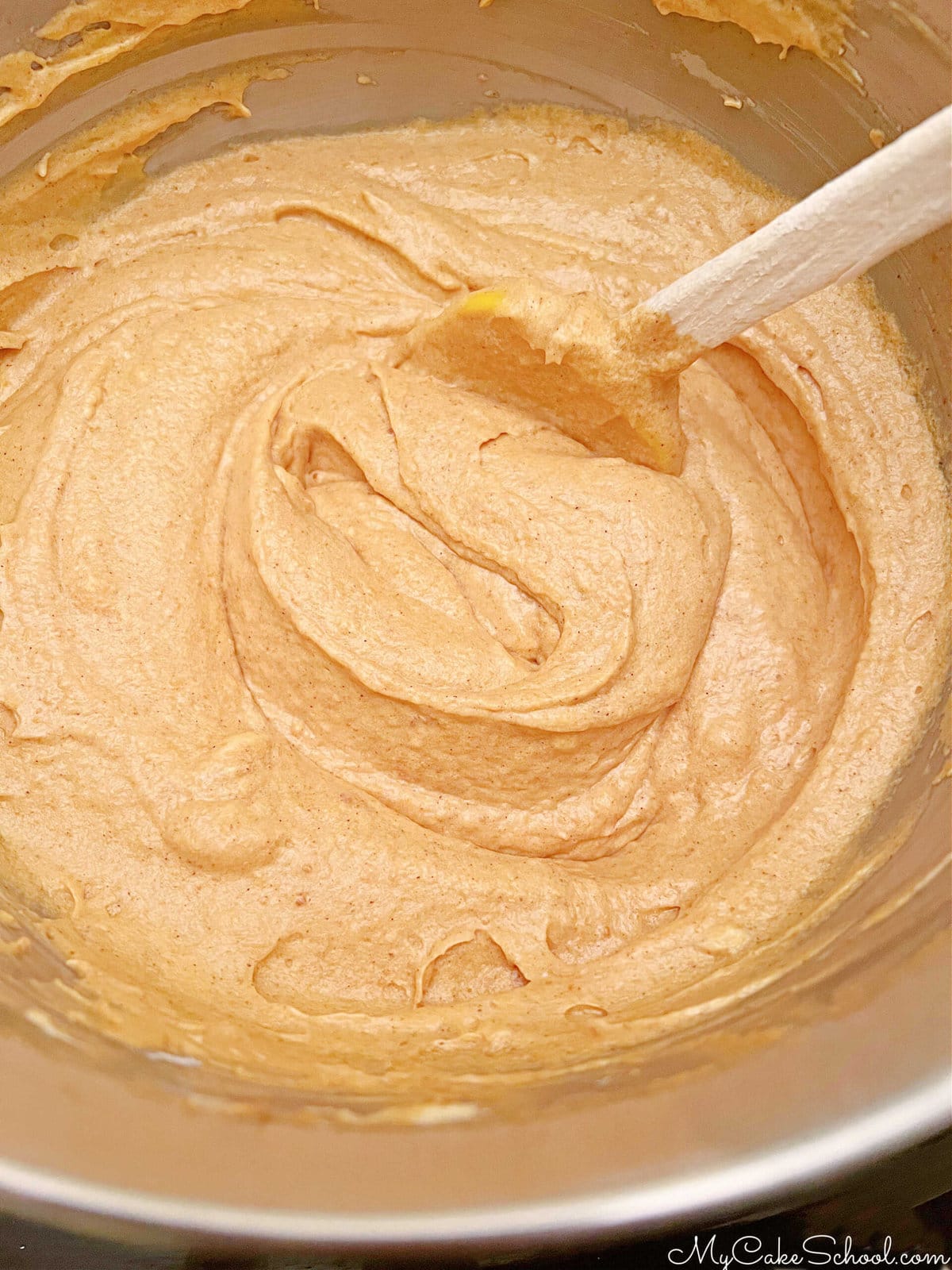 Mixing bowl filled with pumpkin cake batter.