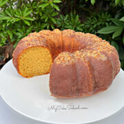 Moist Eggnog Rum Cake, sliced, on a white pedestal.