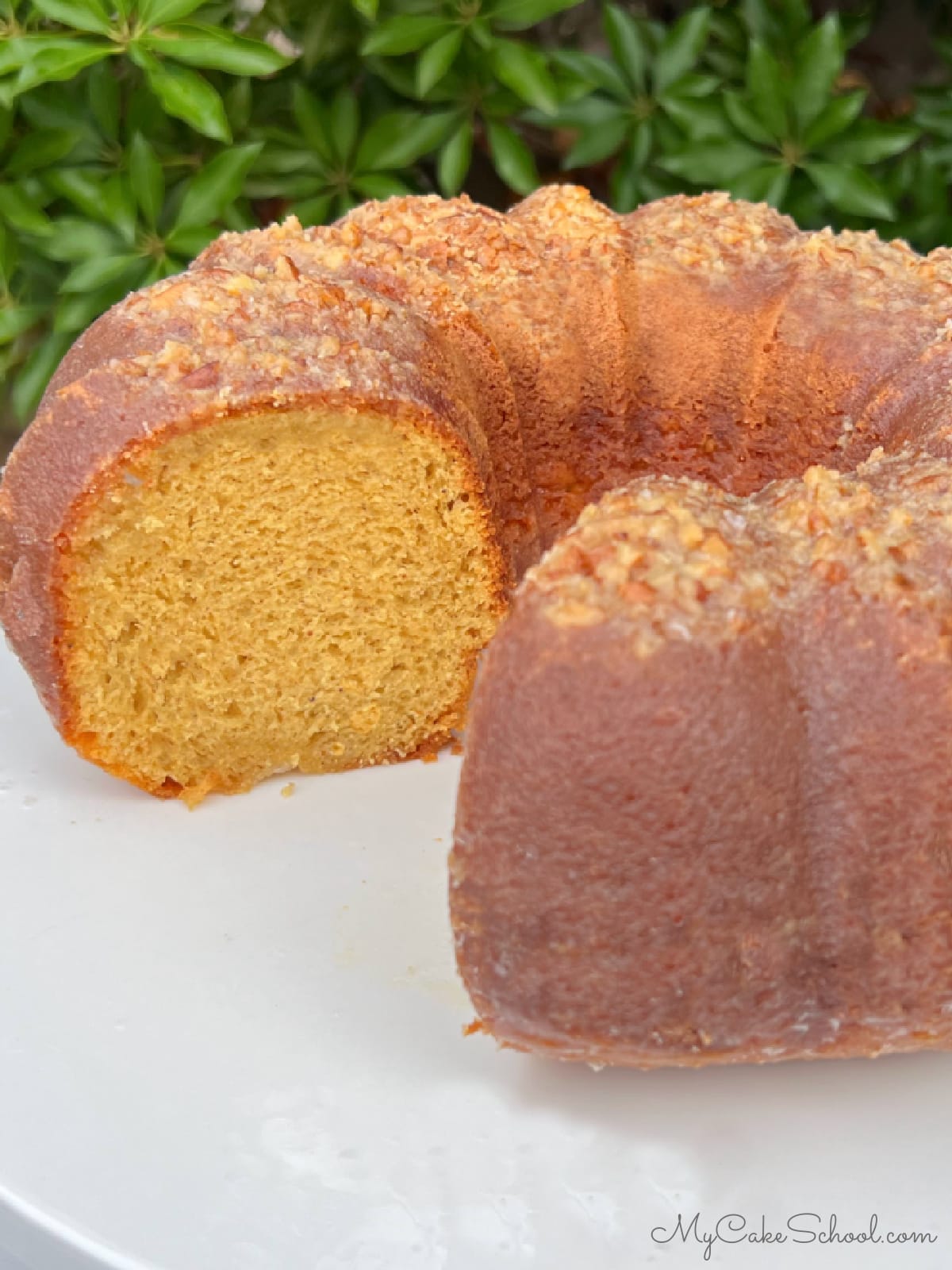 Eggnog Rum Cake, sliced, on a pedestal.