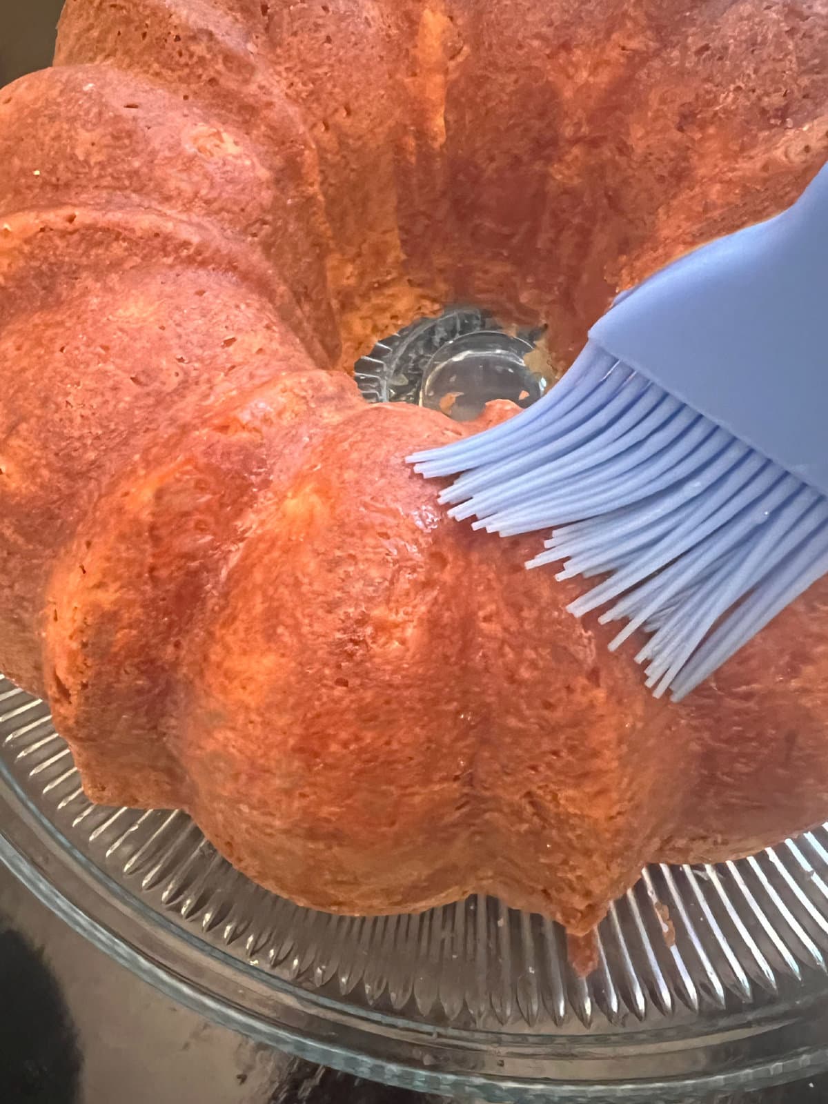 Brushing Pineapple Coconut Cake with pineapple syrup.