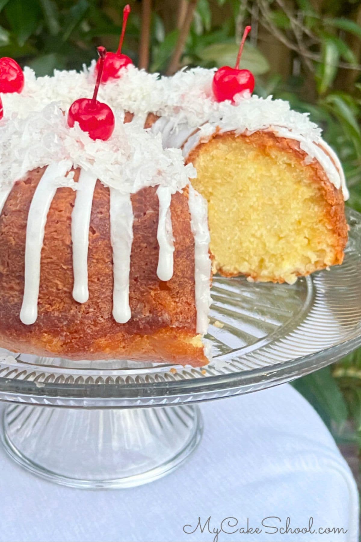 Pina Colada Cake, sliced, on a cake pedestal.