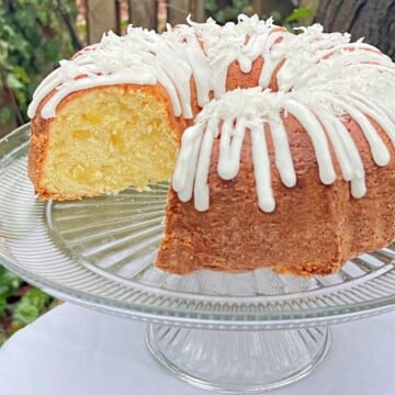 Pineapple Coconut Pound Cake, sliced, on a cake pedestal.